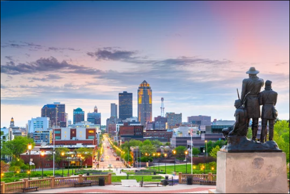 Des Moines, Iowa skyline at dusk with pioneer statue in foreground