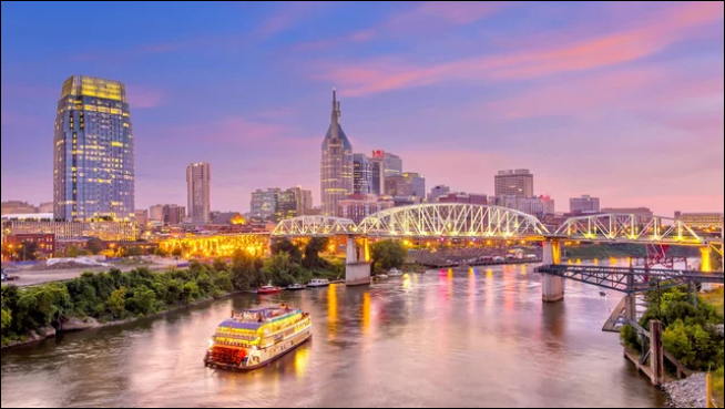 Nashville, Tennessee skyline at dusk with the Cumberland River and Shelby Street Bridge